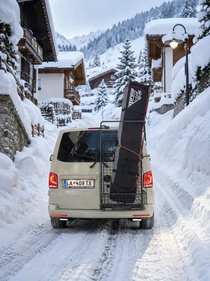 Zurich to St Anton ski transfer – skis and luggage included Zurich to St Anton ski transfer: Taxi Anton VW 4x4 minibus with a ski bag on the rear ski rack on a snowy street in St. Anton am Arlberg